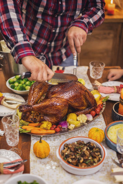 istock Father carving traditional stuffed Thanksgiving turkey 1432953880