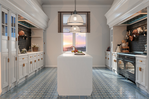 Interior de cocina moderna con gabinetes blancos, isla de cocina y vista al atardecer a través de la ventana photo