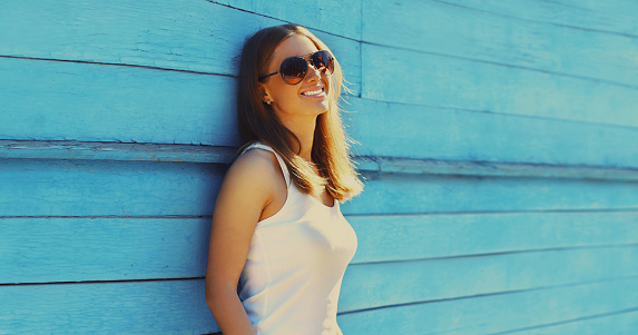 Portrait of beautiful redhead smiling young woman in casual on blue background