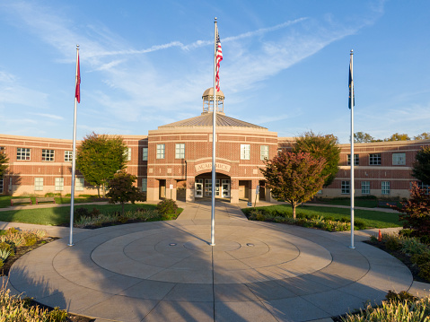 This is a photograph taken from a drone of a high school's academic entrance. It includes 3 flags, the US, the state (PA) and the school. Photo taken about 1 hour after sunrise.