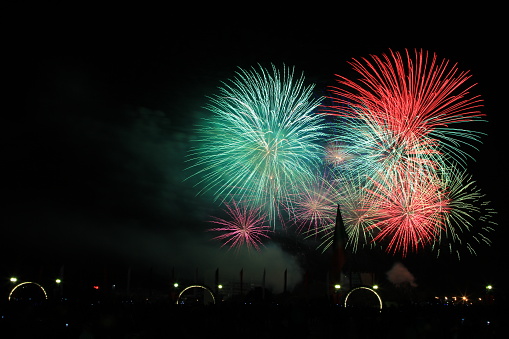 Multicolored fireworks in the dark sky, city day celebration