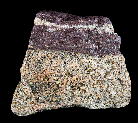 Layered maroon and light speckled  rock magnified.