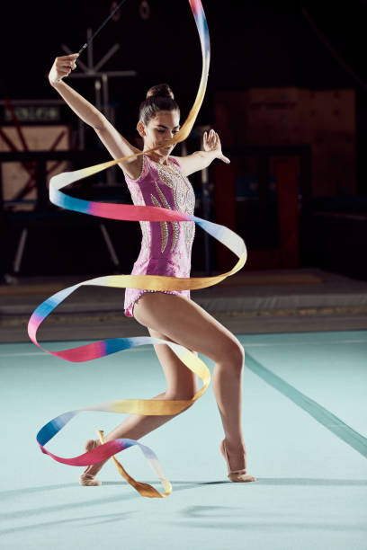 ジムでの競技会でリボンで踊るクリエイティブな女性、ダンスパフォーマンスのために床にダンサー、コンサートでプロスポーツ選手。アスリートガールのイベントトレーニング、有酸素運� - floor gymnastics ストックフォトと画像