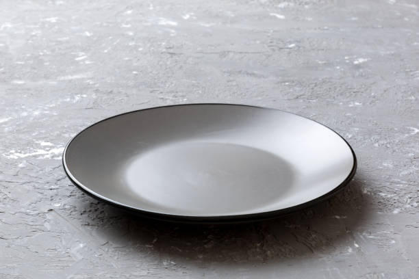 istock Perspective view of empty grey plate on cement background. Empty space for your design 1432968746