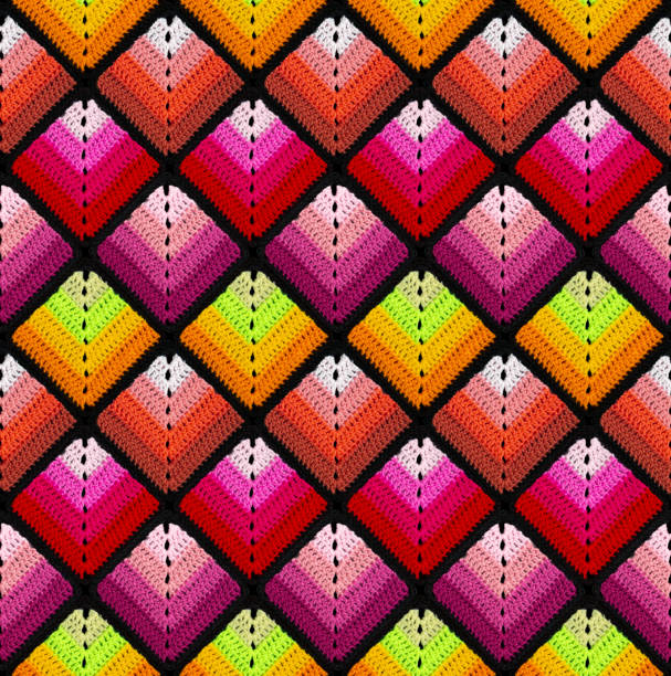 Seamless knitted pattern in the form of gradient rhombuses is crocheted with multi-colored threads. Patchwork style. Analog color combinations.