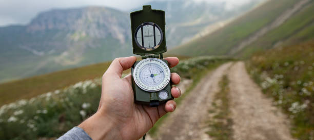 istock Man with compass in hand on mountains road 1432973645