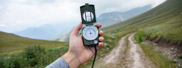 istock Man with compass in hand on mountains road 1432973647