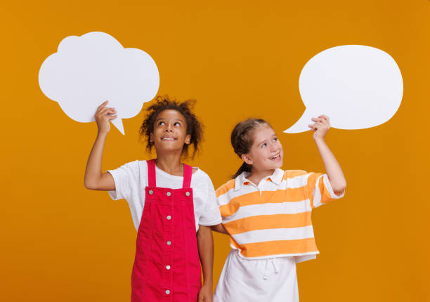 istock Funny multinational girls with thought clouds on  yellow background 1432973737