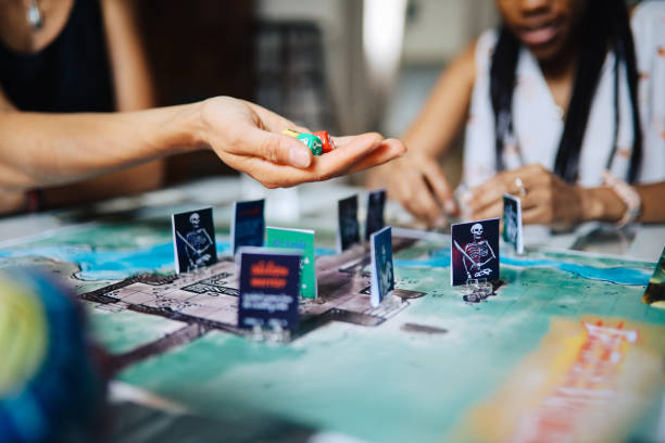 Female friends playing fantasy role playing games on the table. Close up on the one of the characters on the playfield.