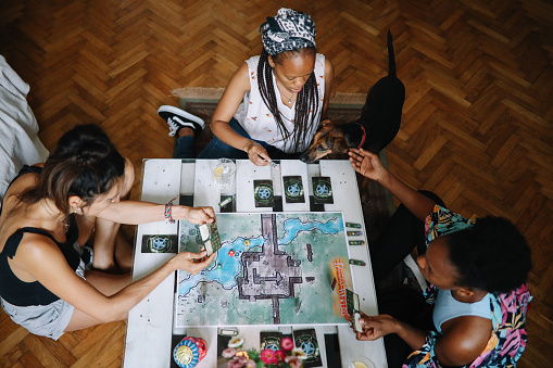 Female friends playing fantasy role playing games on the table. Close up on the one of the characters on the playfield.