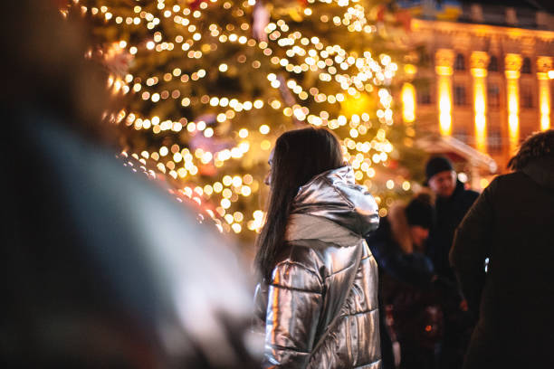 Woman walking in city during Christmas night stock photo