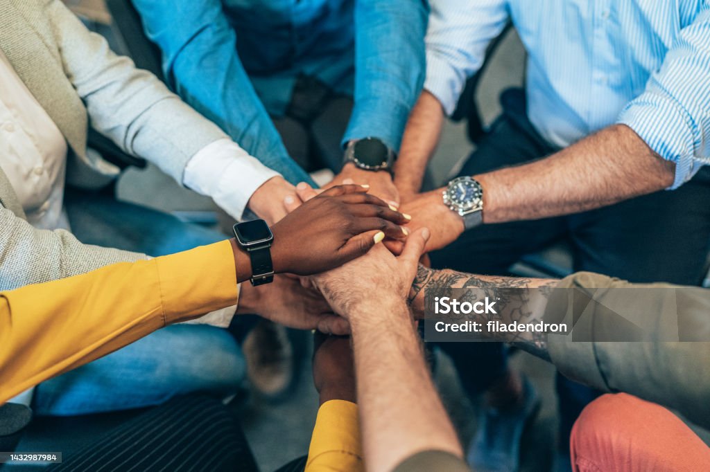 Teamwork Unrecognizable multi ethnic business team holding their hands together. Modern business team holding hands like successful team. Community Stock Photo