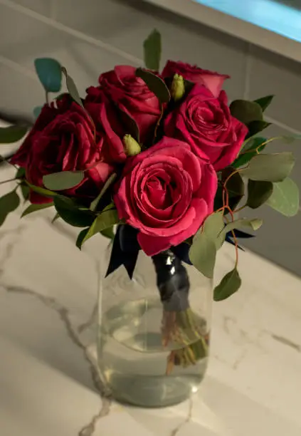 Beautiful Bouquet of Pink Roses in a Glass Mason Jar in a vase with a ribbon with a background