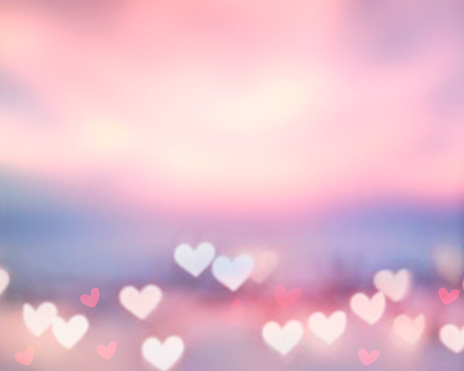 Beautiful sunset bokeh. Blurred hearts texture.Valentine's day background.Romantic glowing backdrop.