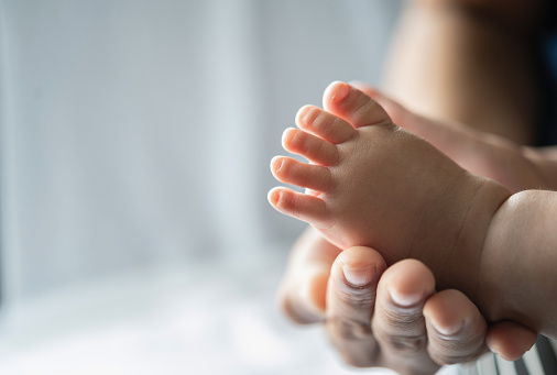 The mother's hand graced the feet of the newborn.