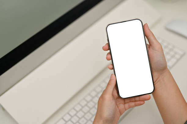 istock A smartphone mockup is in a woman hands over blurred minimal white office desk 1433005367