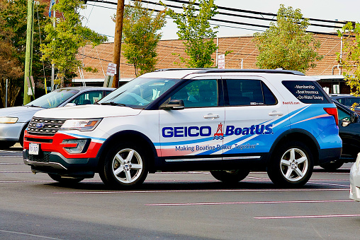 Springfield, Virginia, USA - October 12, 2022: A Ford Explorer wrapped in colorful advertising for GEICO-BoatUS stands out in a parking lot.