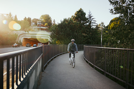 An adult African American man enjoys a bicycle ride on a brisk and sunny autumn day in the Pacific Northwest.   Shot in Seattle, Washington, USA.