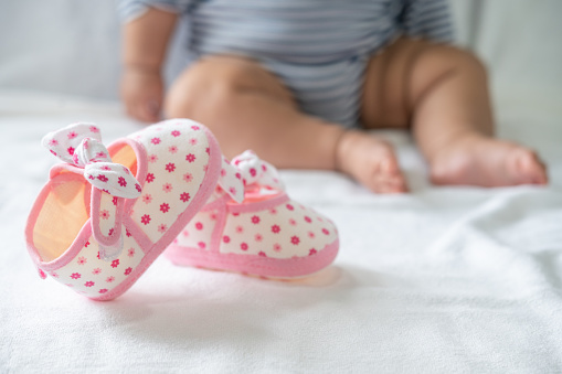 Newborn shoes placed on a white mattress