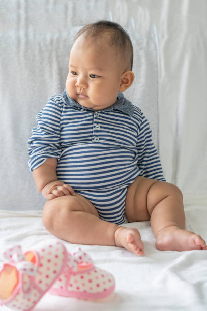 istock A baby learns to sit on a white bed 1433006257
