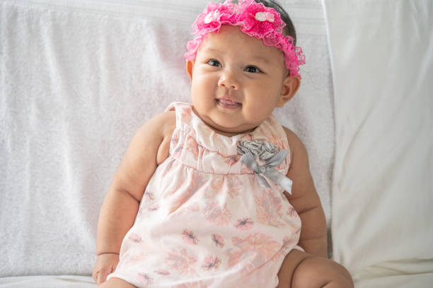 istock A baby learns to sit on a white bed 1433006343