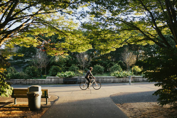 cyclist riding bike in city setting - travel the americas human age viewpoint imagens e fotografias de stock