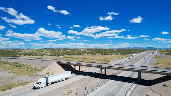 White semi-trucks driving on a interstate 10 in Texas, USA - aerial view