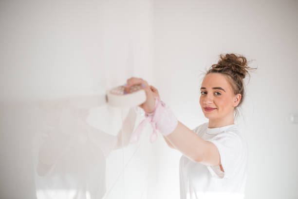 istock Smiling woman putting duct tape on the wall 1433010663