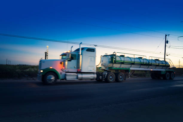 semirremolque que transporta productos químicos que conducen frente a una plataforma petrolera en nuevo méxico - oil industry industry new mexico oil drill fotografías e imágenes de stock