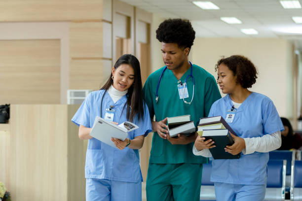 group of medical student holding book walking and talking in university. education and learning medical concept. - medical student healthcare and medicine book education imagens e fotografias de stock