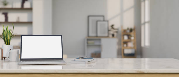 istock Minimal modern tabletop with laptop mockup and copy space over blurred home living room background 1433016368