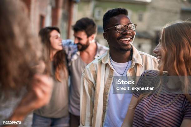 Happy Couple Talking Among Their Friends On The Street Stock Photo - Download Image Now