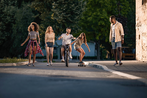 Group of young cheerful friends having fun on the street. Copy space.