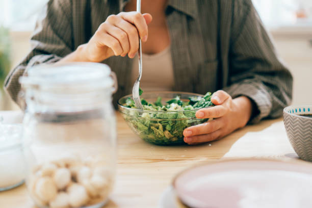cropped unrecognizable woman eats healthy green vegetable salad. - 96 well imagens e fotografias de stock
