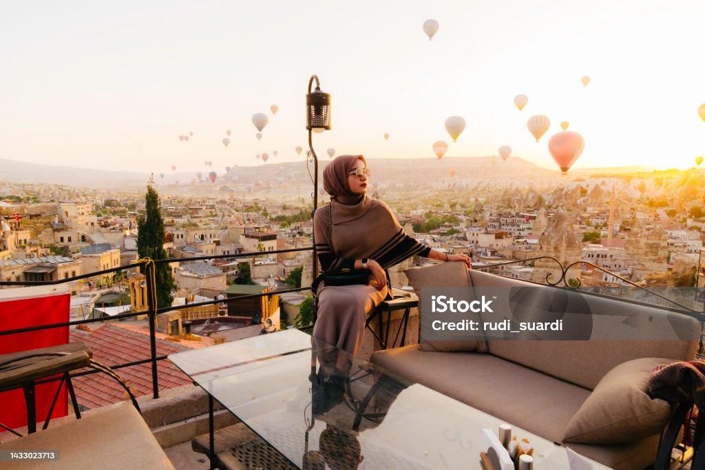 young muslim  woman looking view  of hot air balloon in cappadocia Hijab Stock Photo
