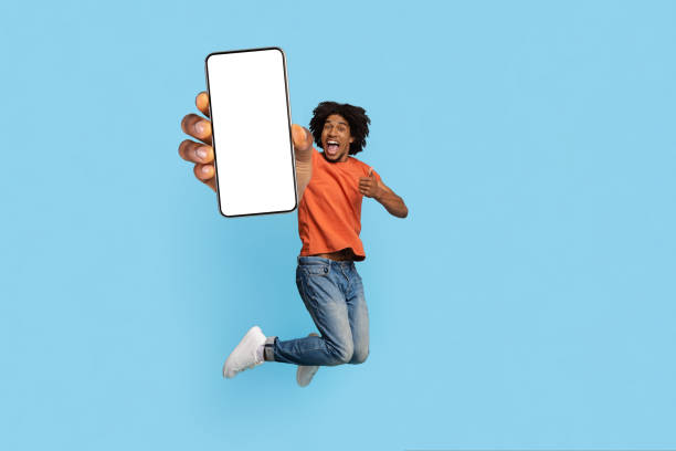 istock Excited african american guy jumping up with smartphone 1433028859
