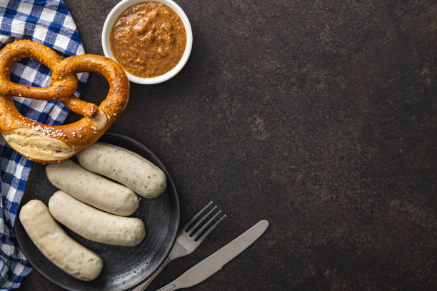 Traditional Bavarian white sausages on plate and pretzes. Traditional Bavarian white sausages on the plate and pretzes. Top view. weisswurst photos stock pictures, royalty-free photos & images