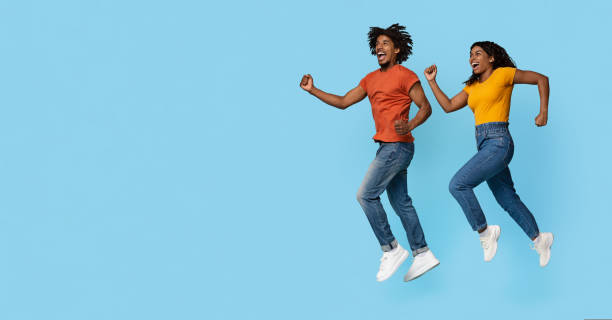 istock Emotional black couple running towards copy space on blue 1433031193