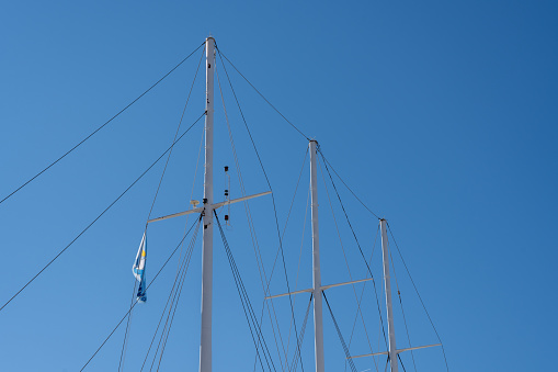 Sailboat mast with clouds and blue sky.