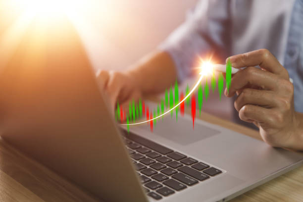 istock businessman using a laptop to plan a strategy that shows a positive digital technology graph chart. The concept is growing stocks, investing, stock marketing, and success. 1433038433