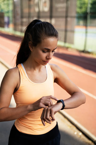 istock Beautiful woman in sportswear using smartwatch 1433038531