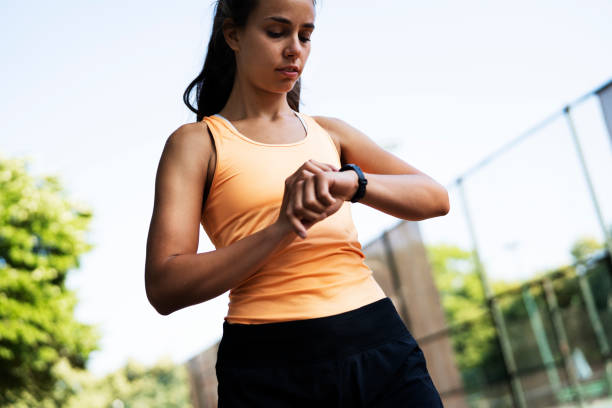 istock Beautiful woman in sportswear using smartwatch 1433038532
