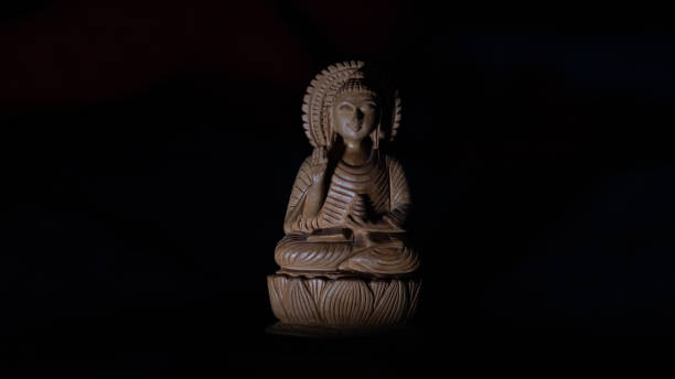 WOODEN BUDDHA STATUE IN LUMINANCE LIGHTING. stock photo