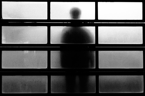 Silhouette of a person standing on frosted glass