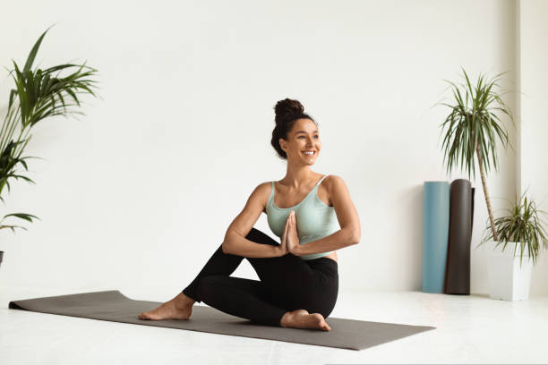 portrait of beautiful young female making yoga practice in light studio - posing imagens e fotografias de stock