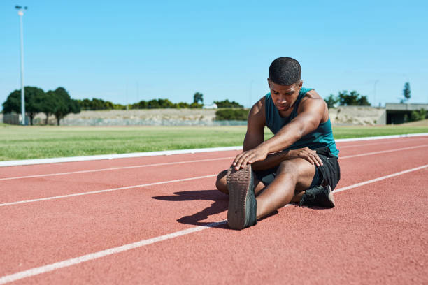 Free Stock Photo of Athlete stretching on a sunny track field ...