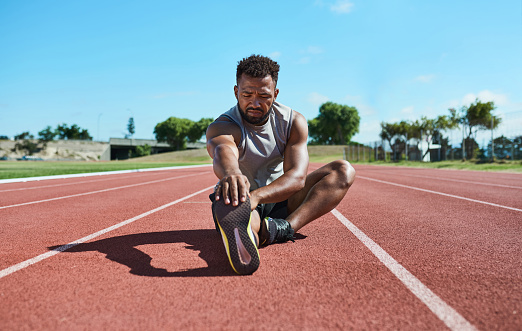 Stretching, shoes and fitness athlete runner on stadium ground with blue sky mock up for marathon training. Professional sports black man legs for workout run, exercise motivation and muscle goals