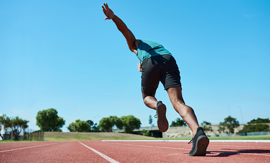 Athlete, running and track for fitness, speed and motivation for sport competition. Runner, training and exercise alone in summer on field to be ready for race, sprint or sports event in New York