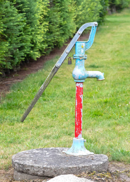 istock Old grunge water pump on a field of grass 1433047505