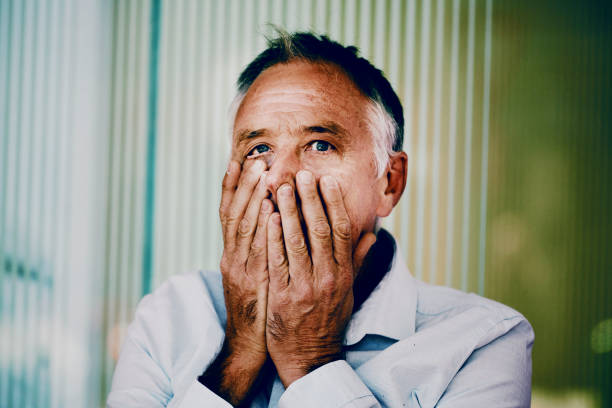 istock Middle aged man with hands covering his mouth 1433050907